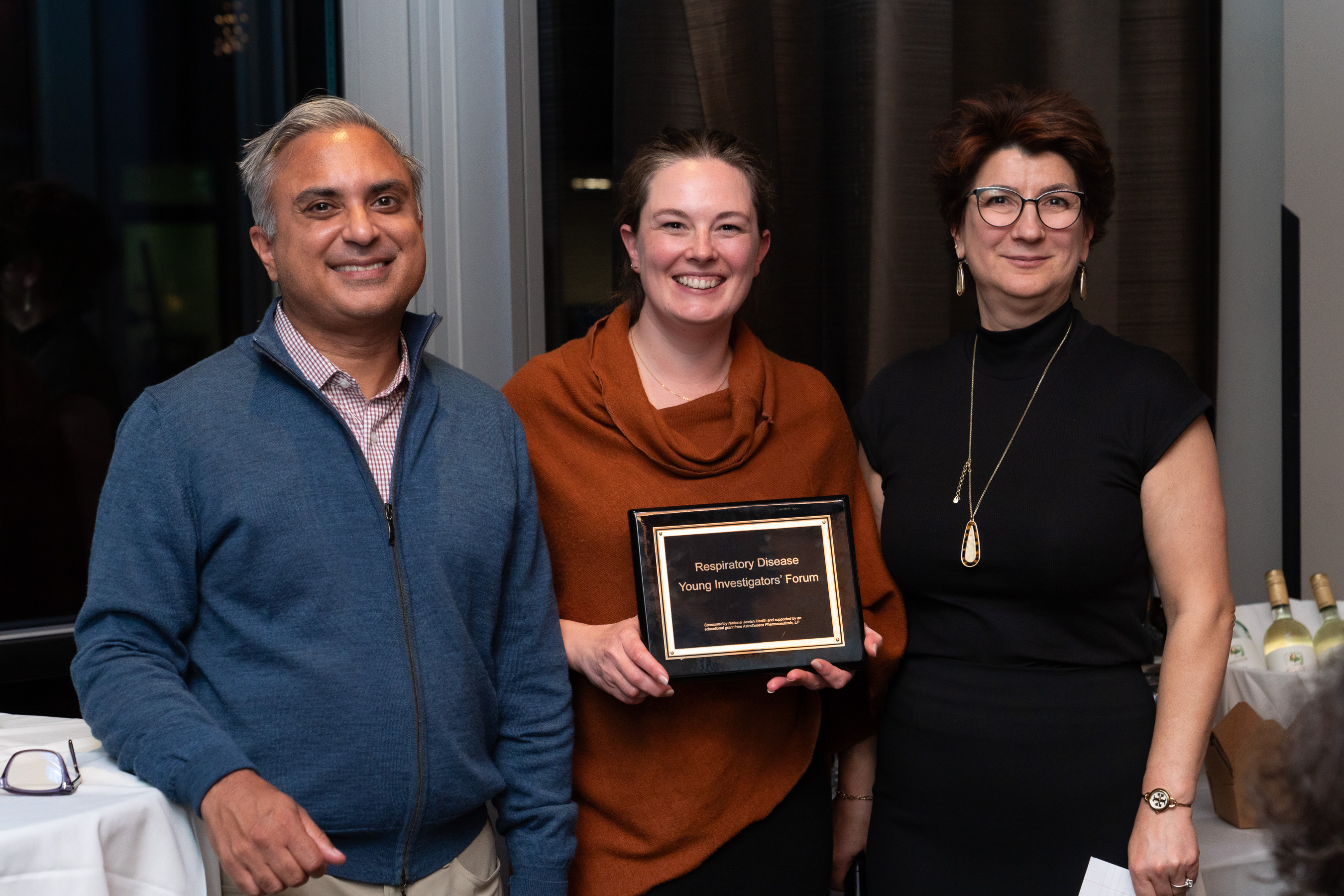 Sarah Holton holding award plaque from the Respiratory Diseases Young Investigators' Forum. 