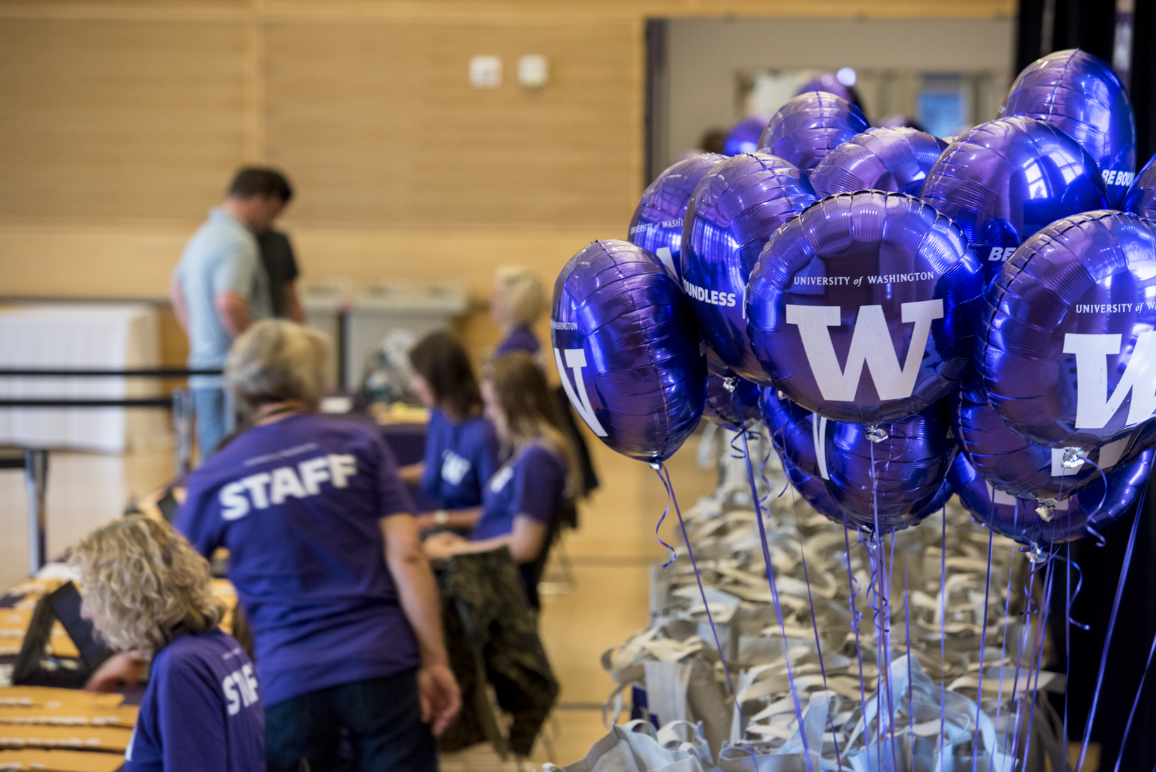 UW purple balloons and a person wearing a purple tshirt with "staff" printed on the back.