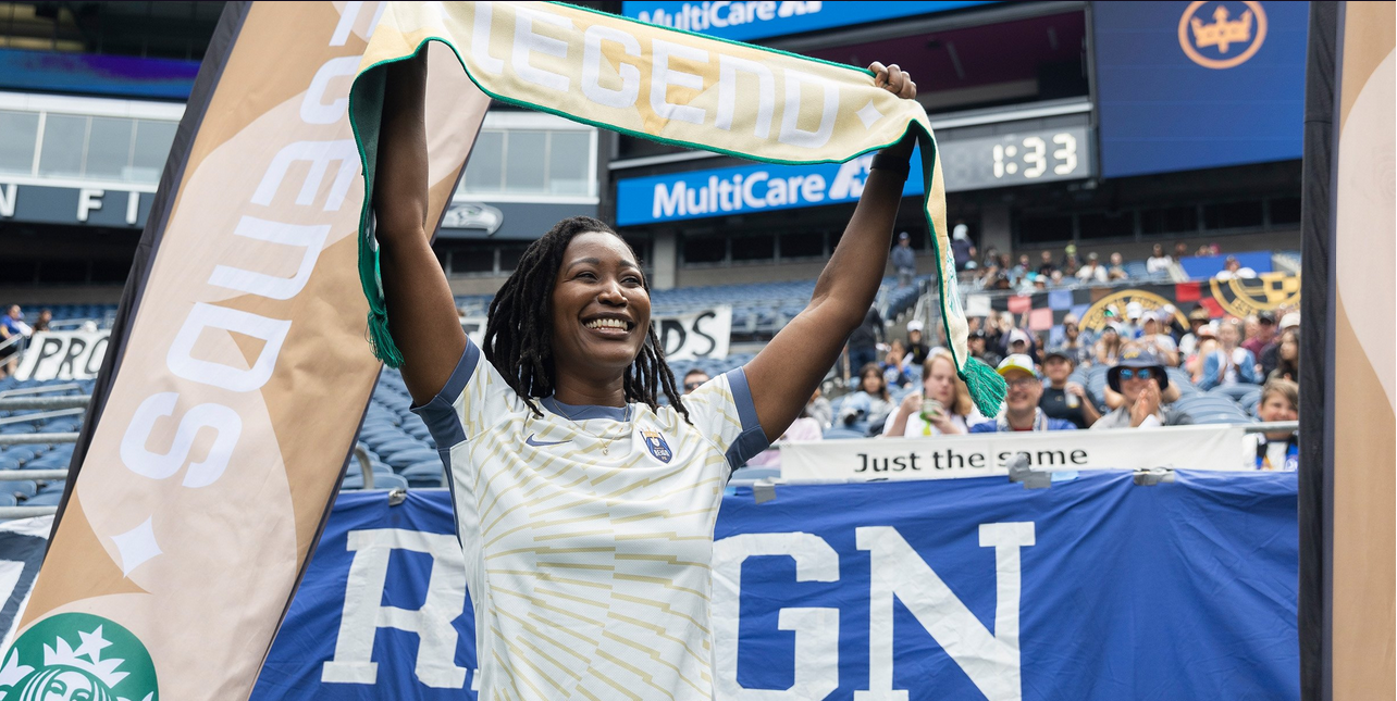 Dr. Rachel Issaka holding Seattle Reign FC banner