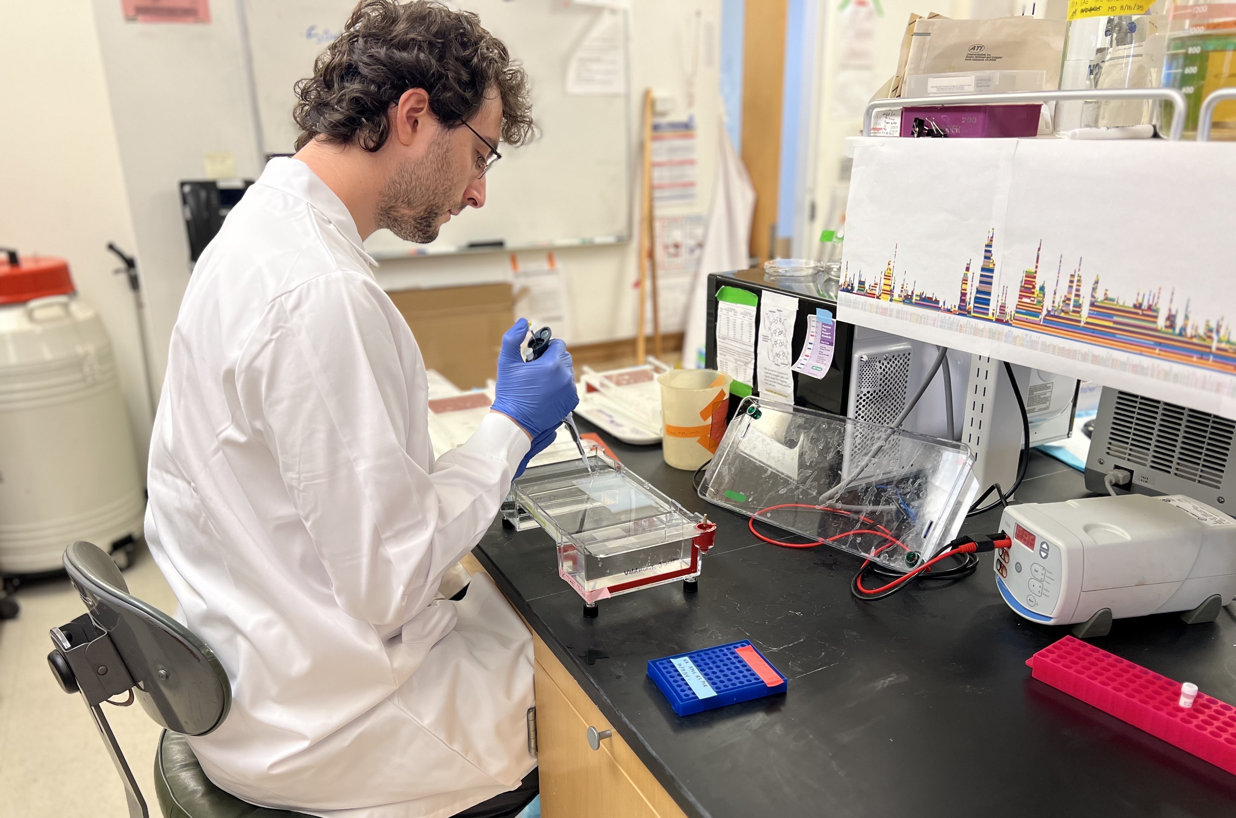 Human genetics research scientist Eli J. Kaufman conducts a genomics lab procedure. Image by Paul Valdmanis