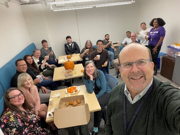 Faculty and staff around a table drinking tea