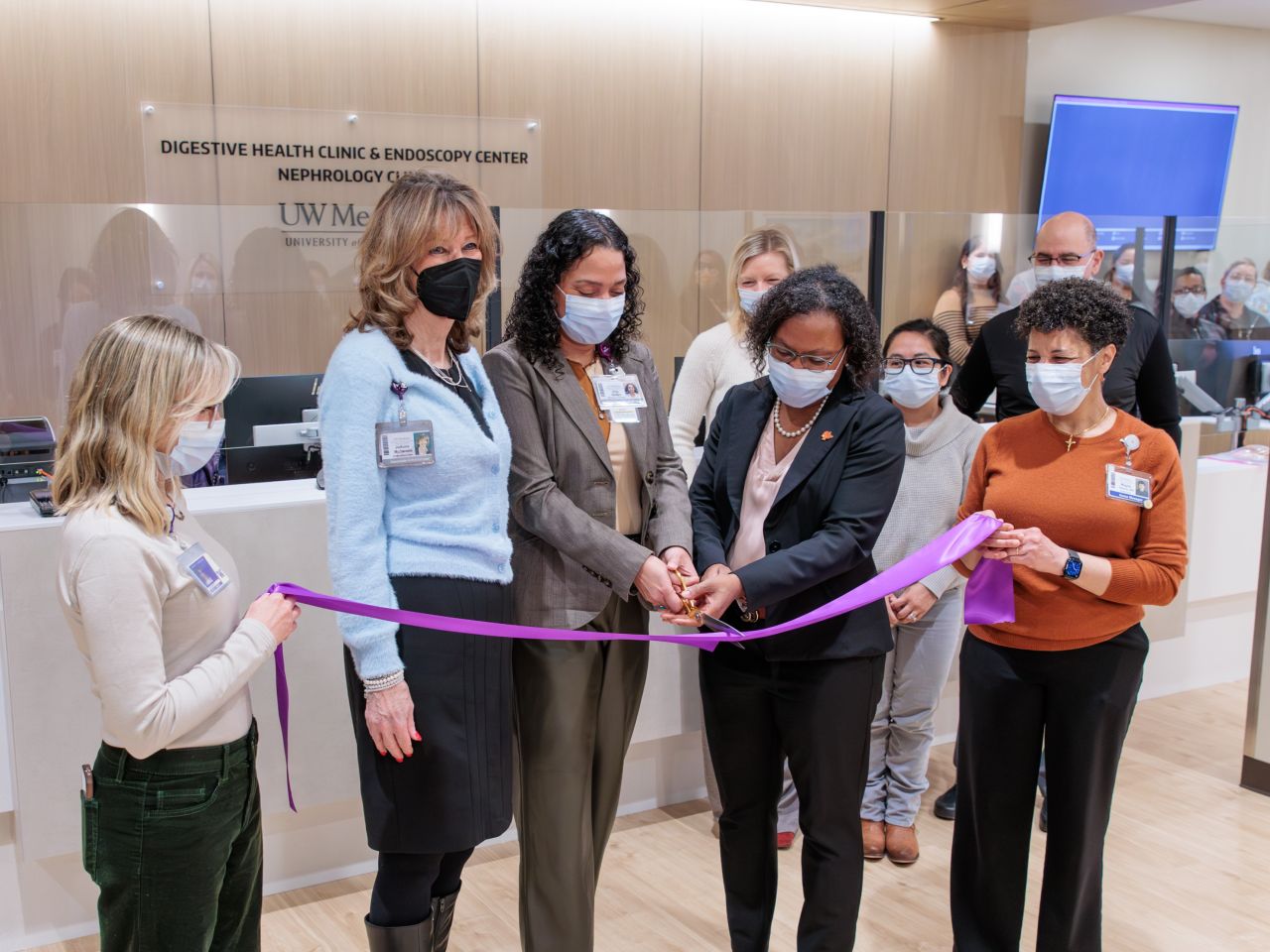 Dr. Rotonya Carr cutting a ribbon in front of new clinic reception desk