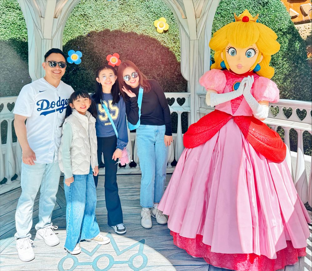 Tram Phan and her family, with Princess Peach character at a theme park