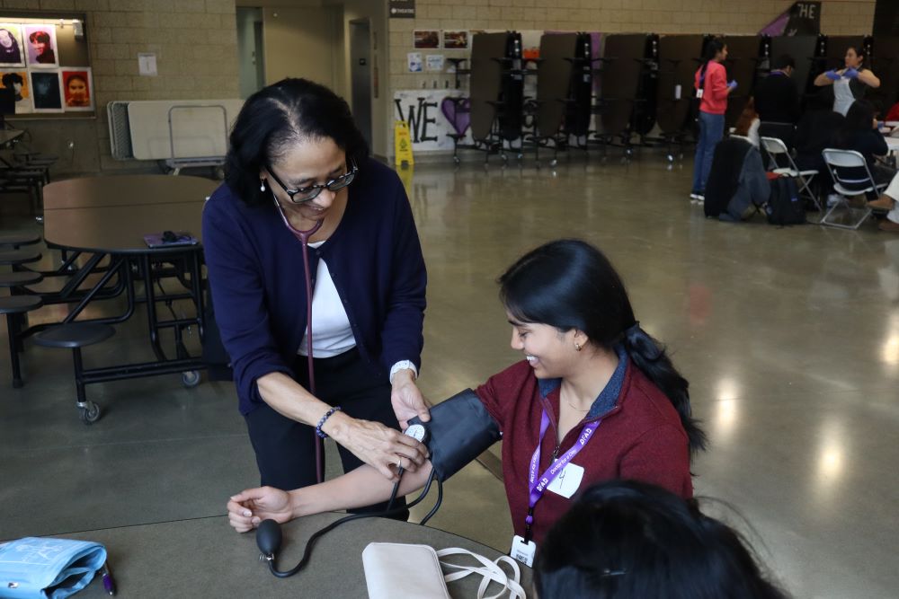Student using blood pressure cuff
