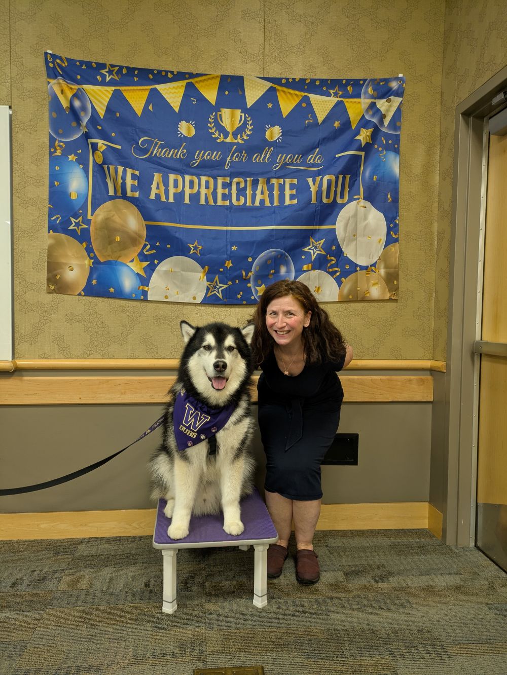 March and Dubs the Husky, in front of a banner that reads "We appreciate you"