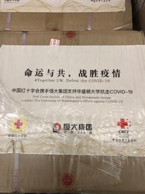 Label on box of donated mask reads "Together UW, Defeat the COVID-19"