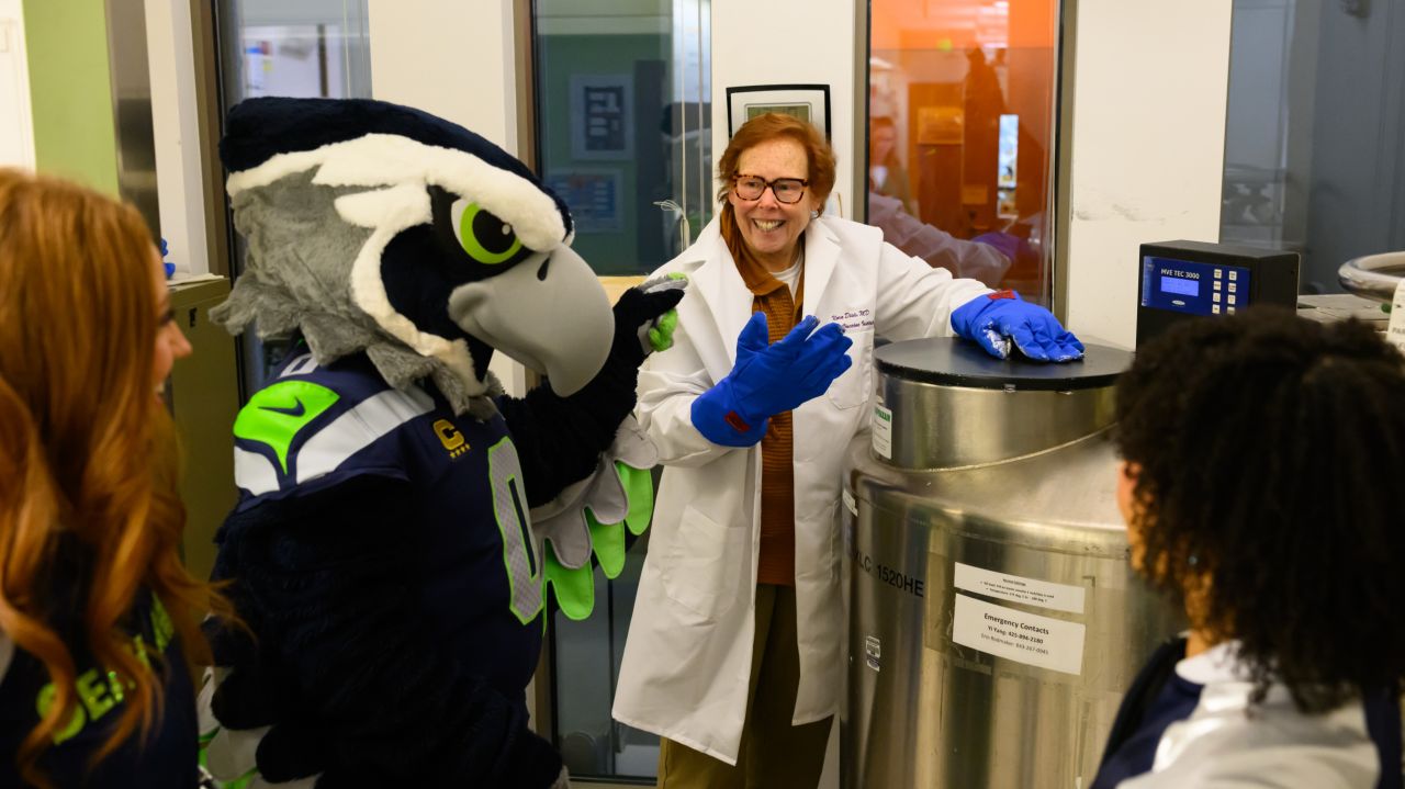Nora Disis in her lab with Seattle Seahawks mascot. Photo credit: Edwin Hooper/Seattle Seahawks