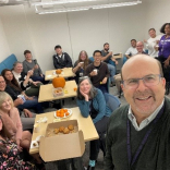 Faculty and staff around a table drinking tea