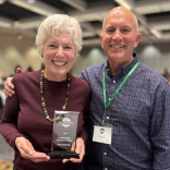 Taryn Oestreich and her husband. Taryn is holding an award. 