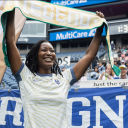 Dr. Rachel Issaka holding Seattle Reign FC banner