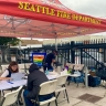 Pop up staff member talking with participant at table in the park