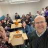 Faculty and staff around a table drinking tea