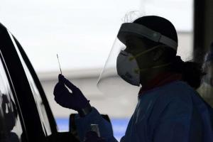 UW research coordinator Rhoshni Prabhu testing a passenger at a free COVID testing site in Seattle. AP photo/Elaine Thompson.
