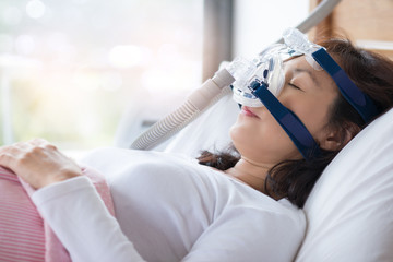 Woman sleeping with a CPAP. Adobe stock image. 