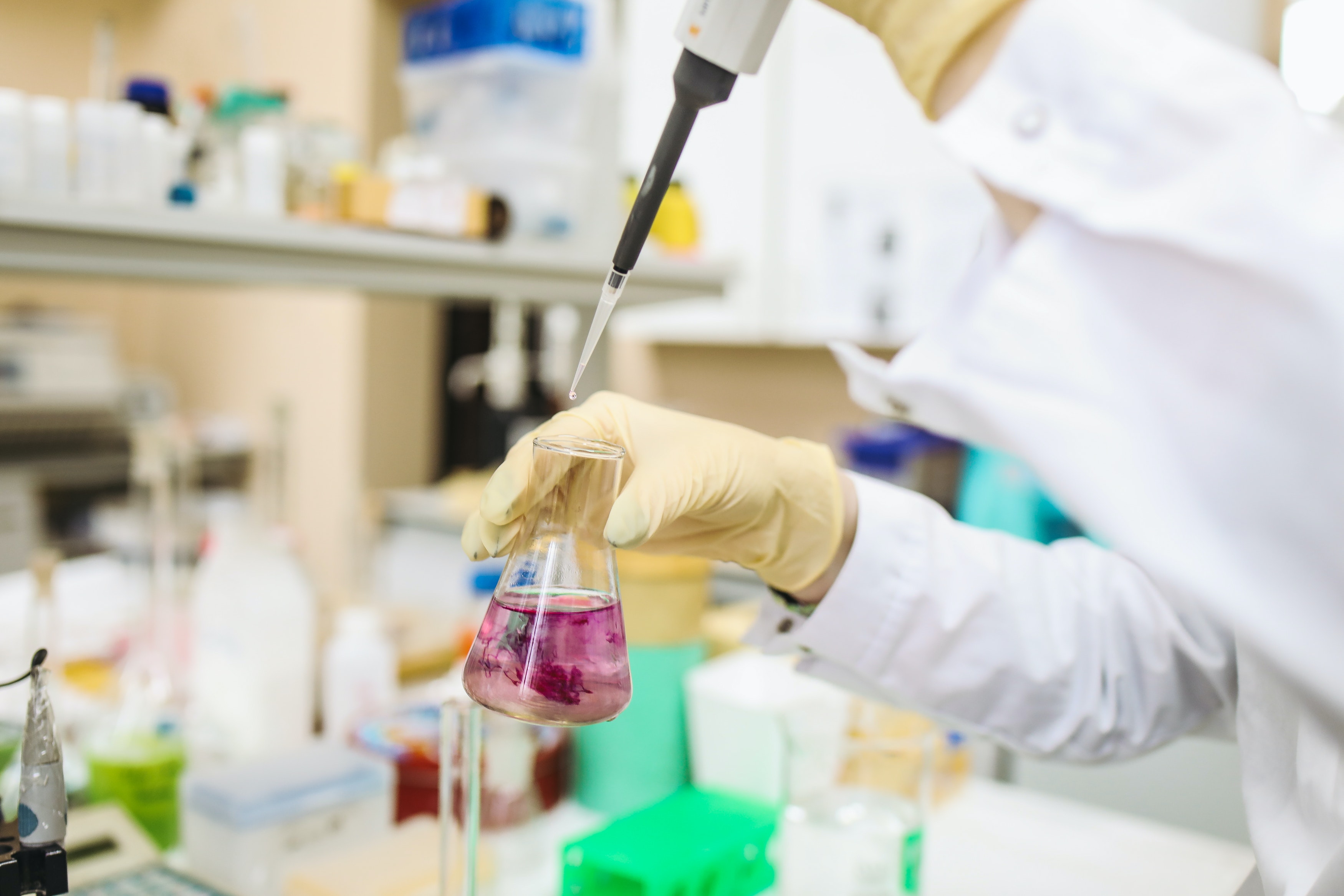 Scientist holder a beaker in a medical research lab. 
