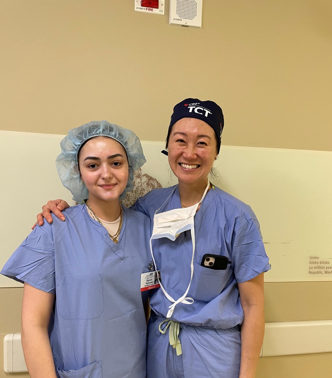 Doctor and a student smiling in scrubs