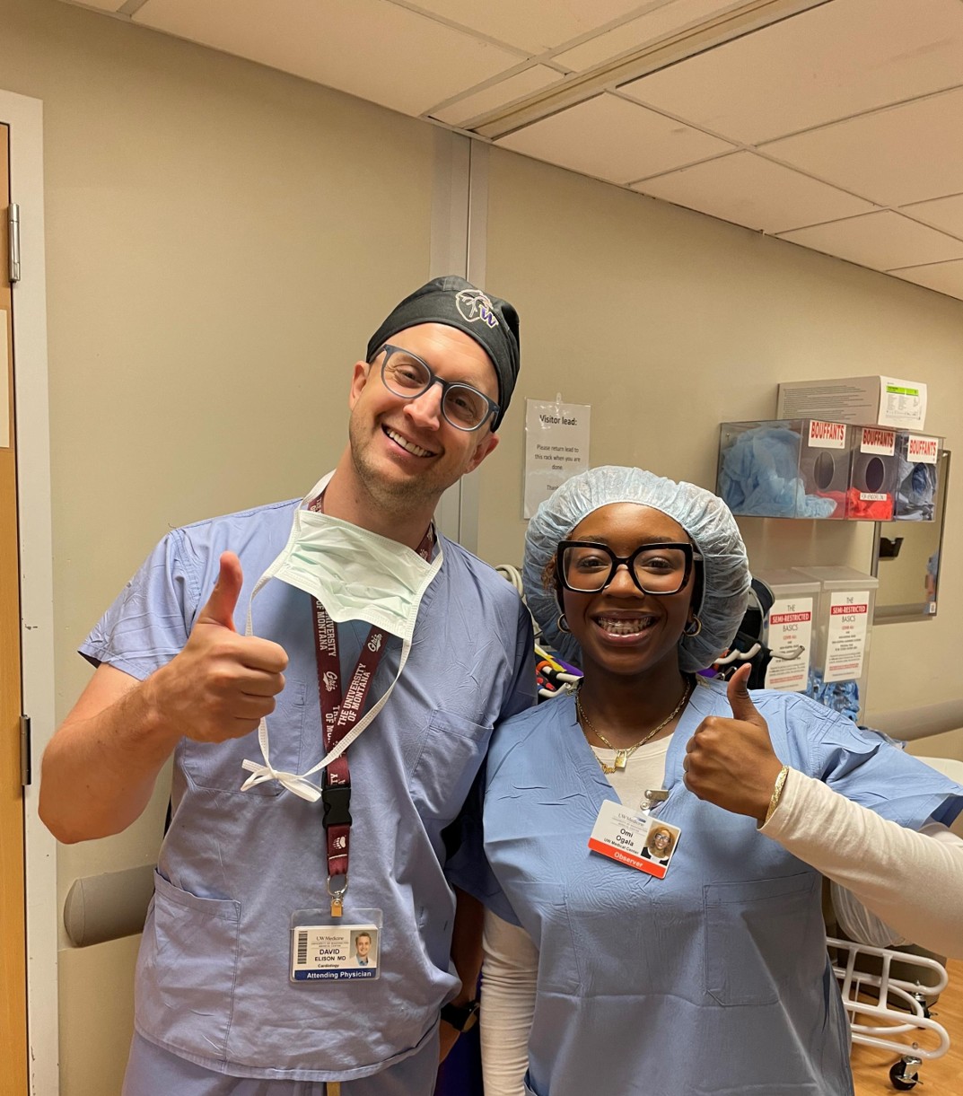 A doctor and students smiling in scrubs