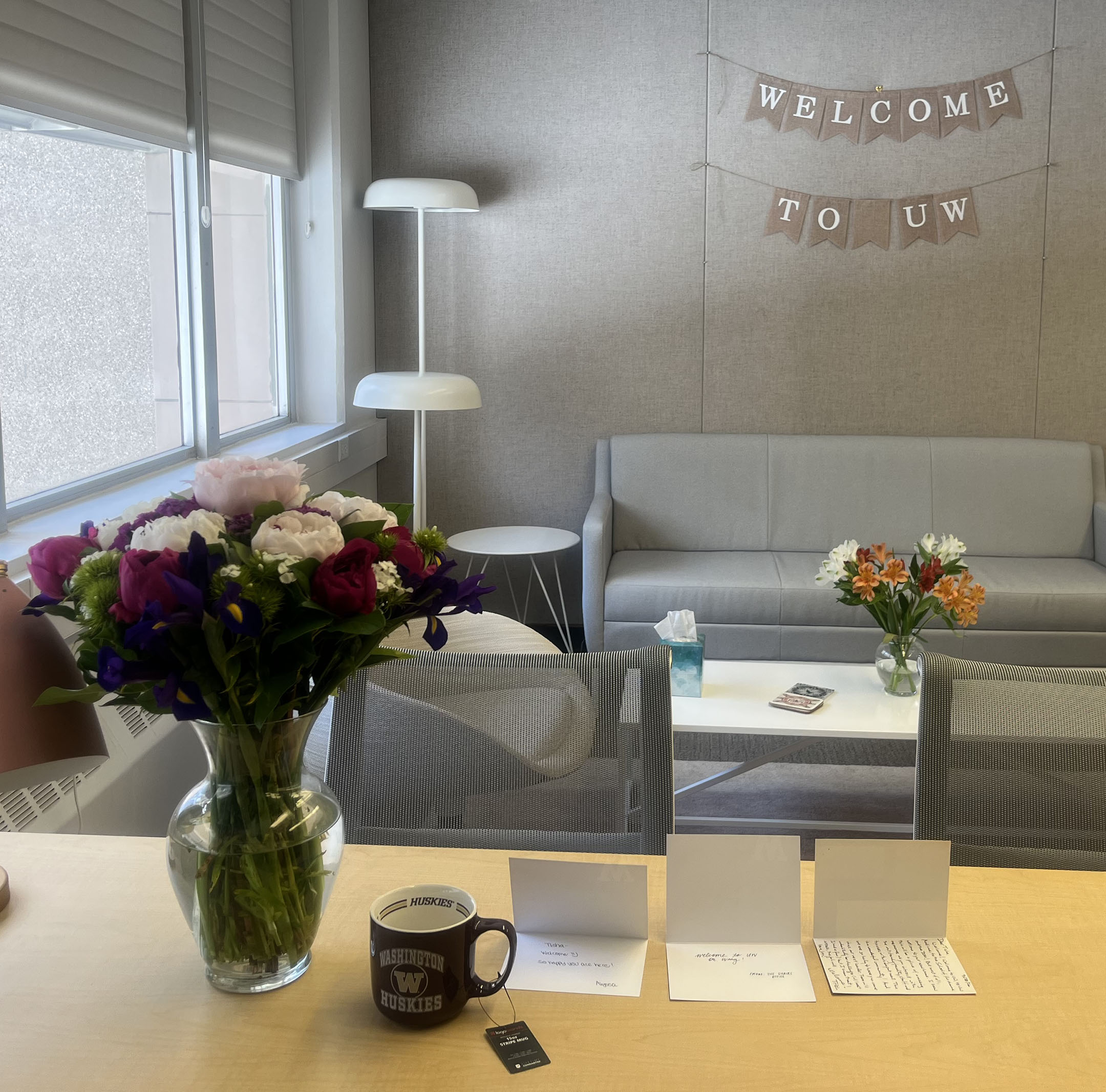 Office space with flowers and a "Welcome to UW" hanging banner on wall