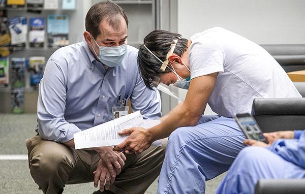 Dr. Tim Dellit, chief medical officer at UW Medicine comforted Dr. Ong after he received the vaccination.